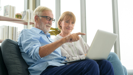 older couple using laptop to check pension information