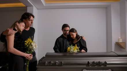 a man and a woman looking at a casket