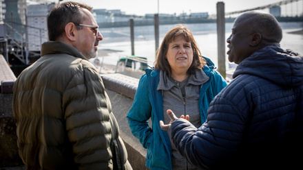 three people talking on the street