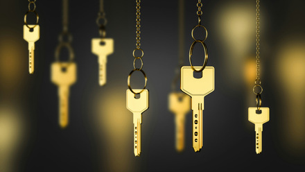 shiny gold keys on chains over blurry black background