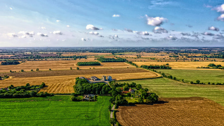 brown and green fields under cloudy sky in suffolk