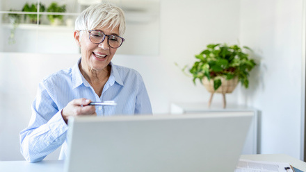 woman wearing glasses at home working on a laptop