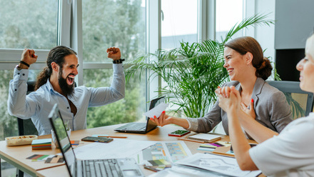 smiling man receiving a certificate sitting at office table